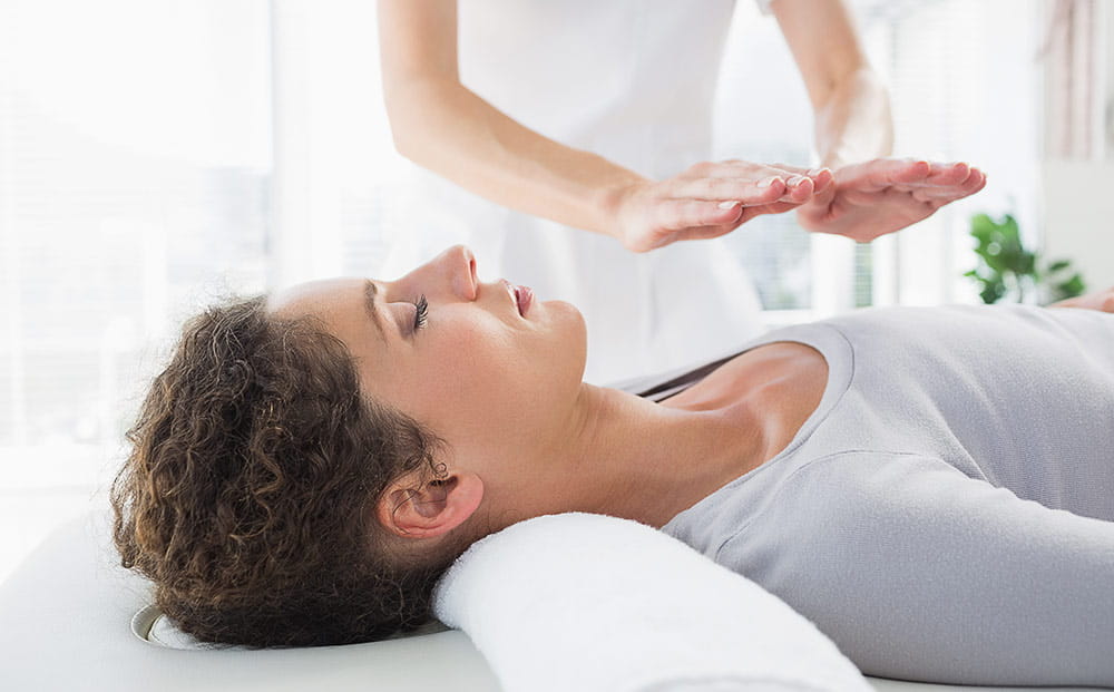 A young woman having reiki treatment