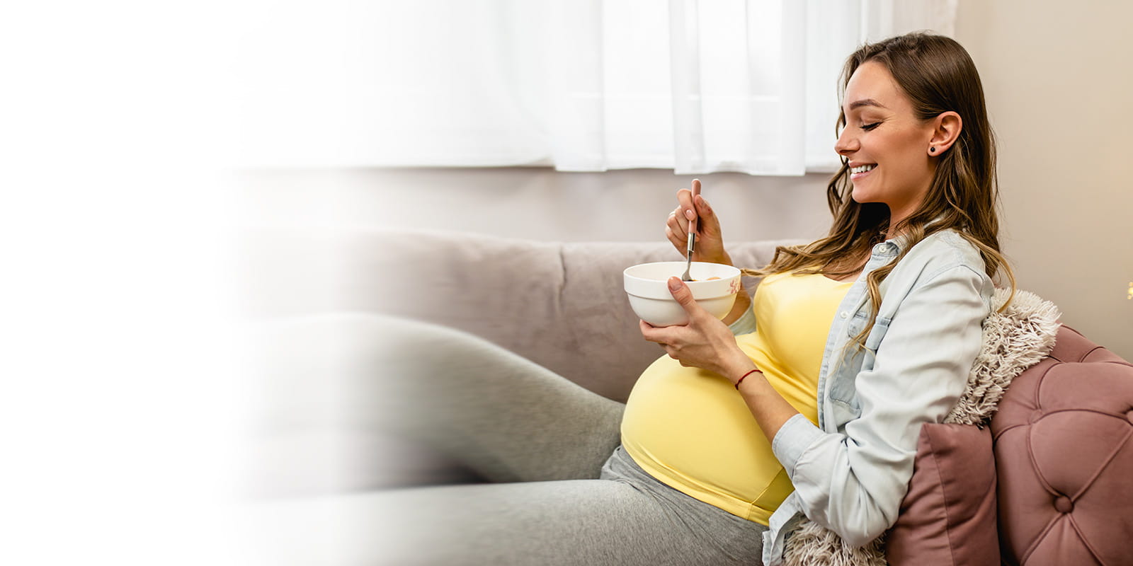 Pregnant women eating on couch