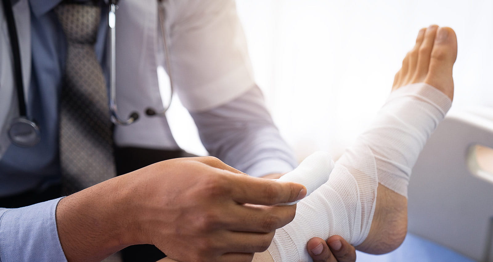 A doctor gives expert treatment toa patient with a broken ankle