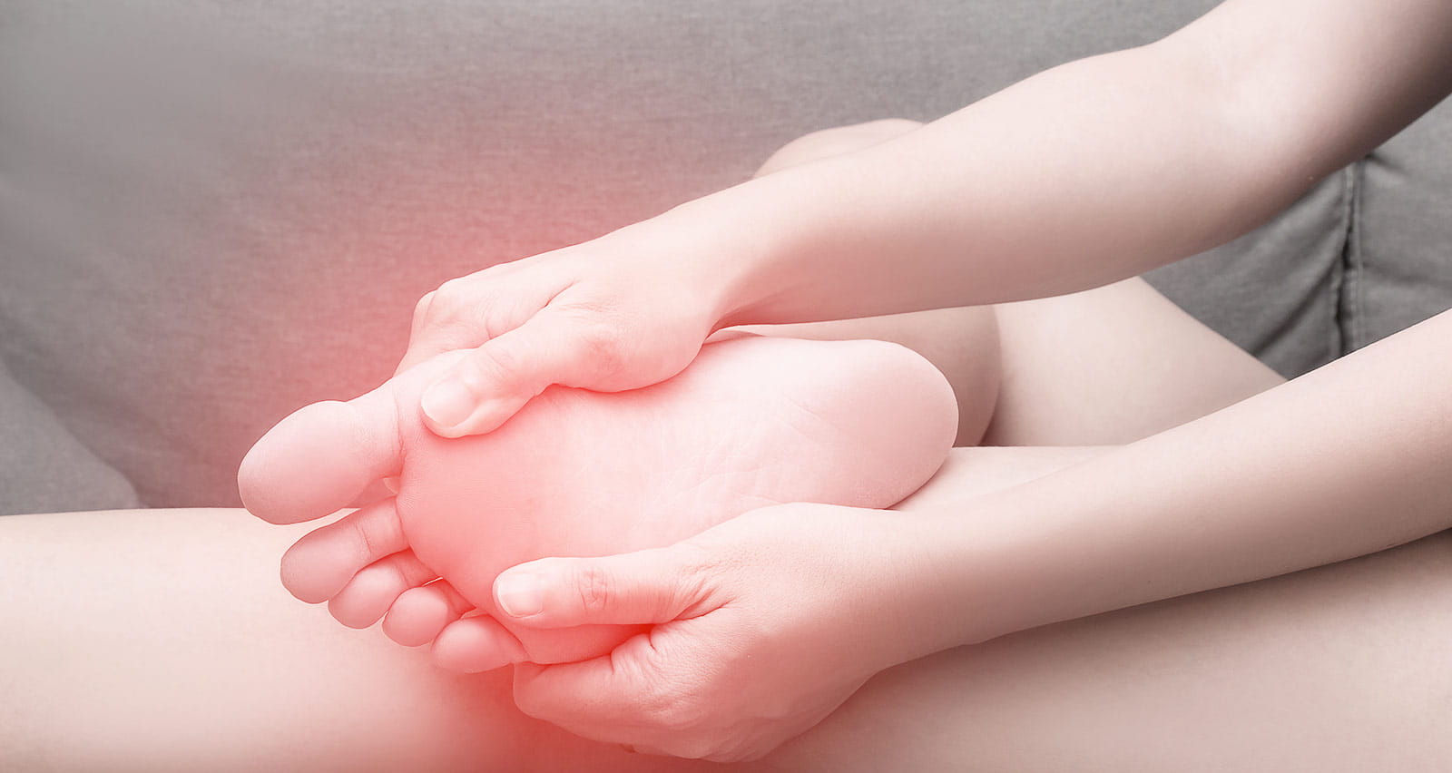 A woman suffering from sesamoiditis massages her foot