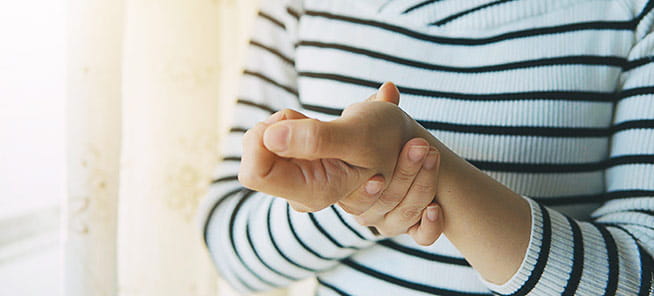 Woman massaging her hand and wrist