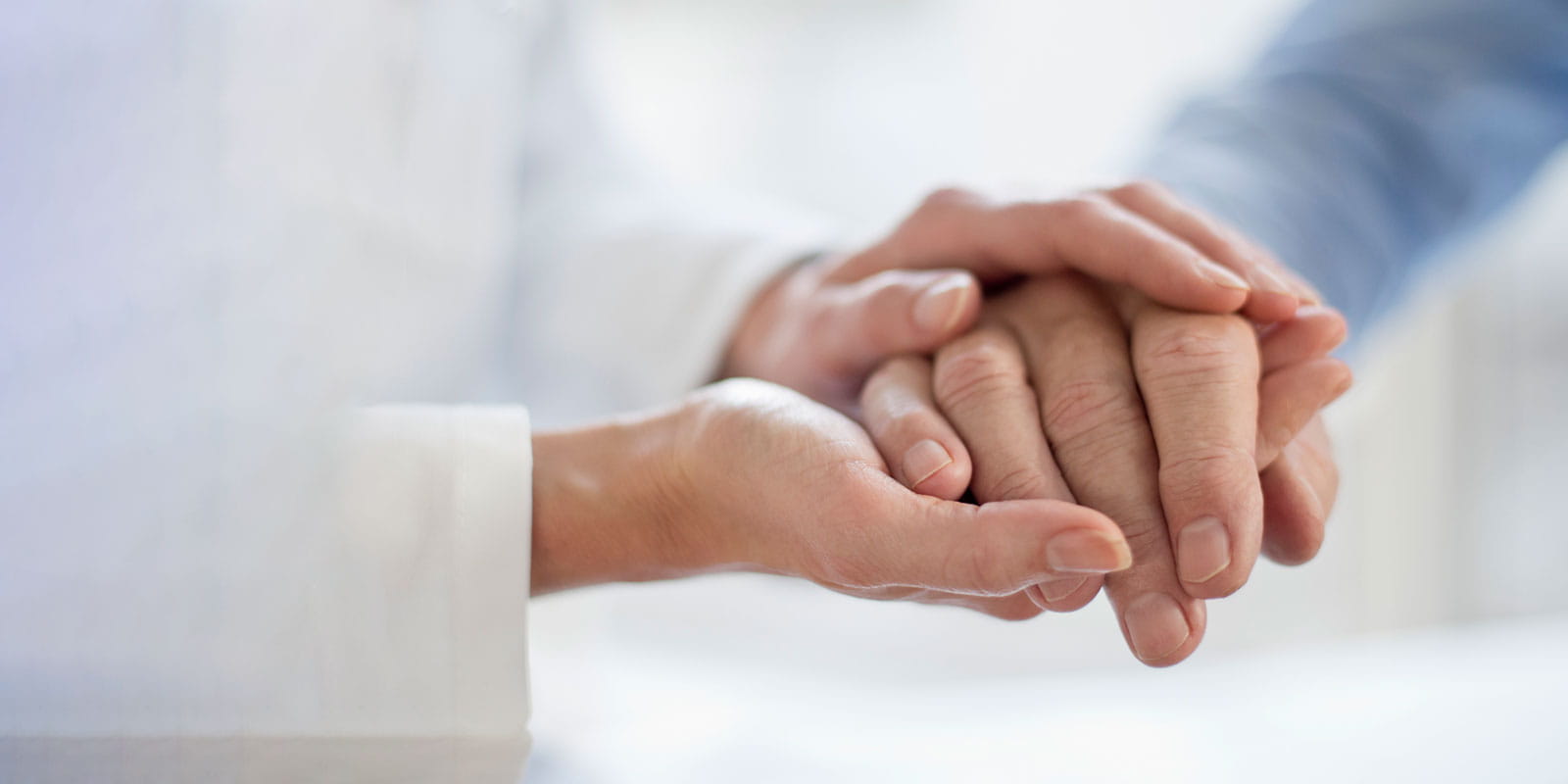 Female doctor holding patients hand