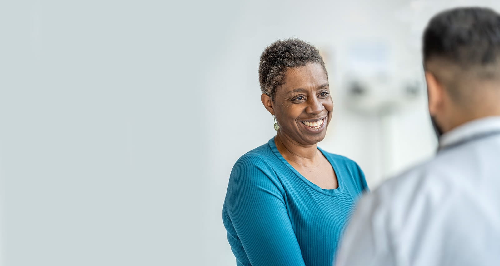 A senior woman of African decent sits with her male doctor during a medical appointment