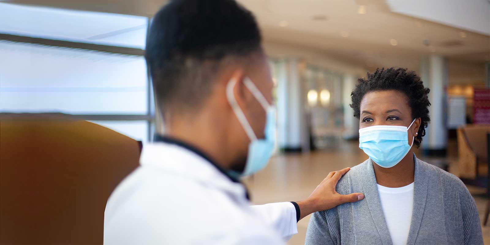 Male doctor greeting female patient