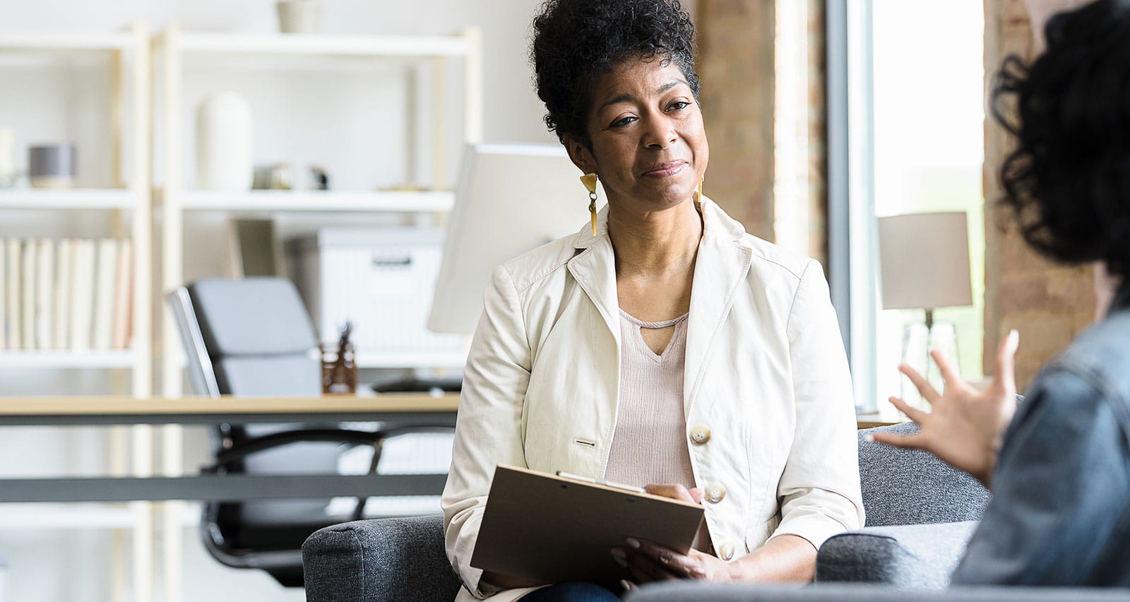 A therapist sits and listens intently to her patient