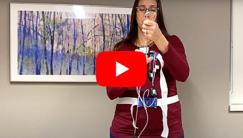 A woman demonstrates how to hookup the NOMAD Home Sleep Device
