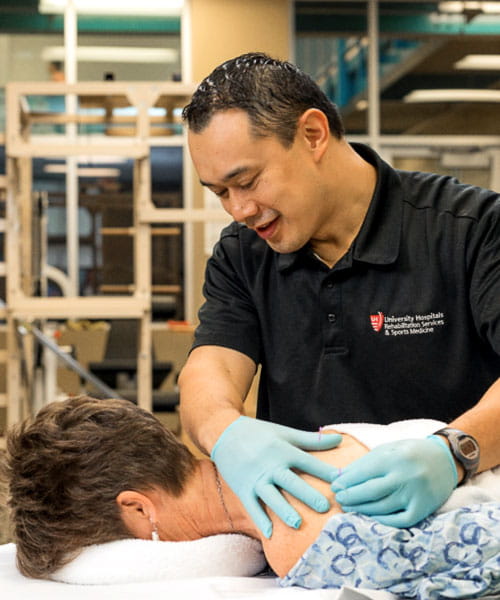 Needle and hands of physiotherapist doing a dry needling