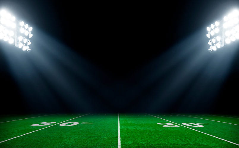 Football field at night with stadium lights