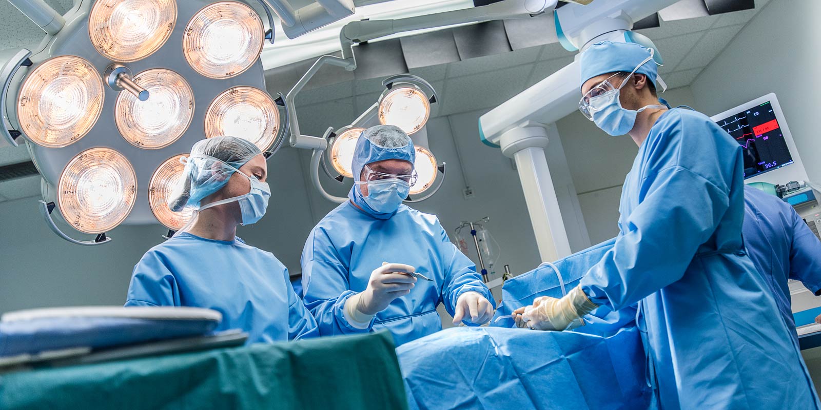 Surgeons performing surgery in operating theatre