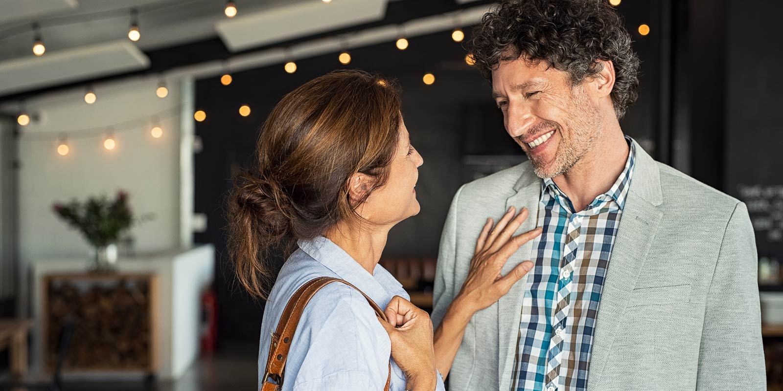 Mature couple smiling and looking each other at cafe.