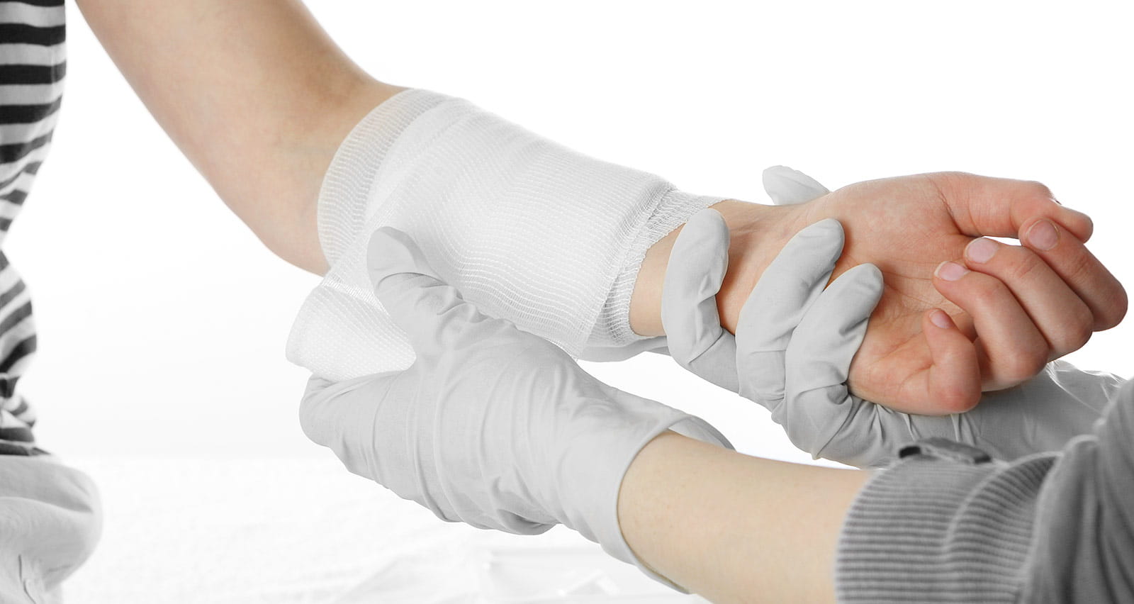 A provider is dressing a patient's wound to the wrist area